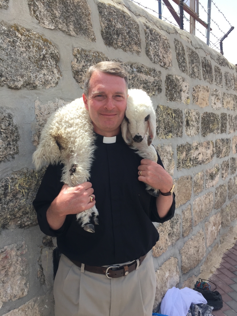 In his Sunday attire, the Rev. Jeff Miller stops to pose with a lamb.